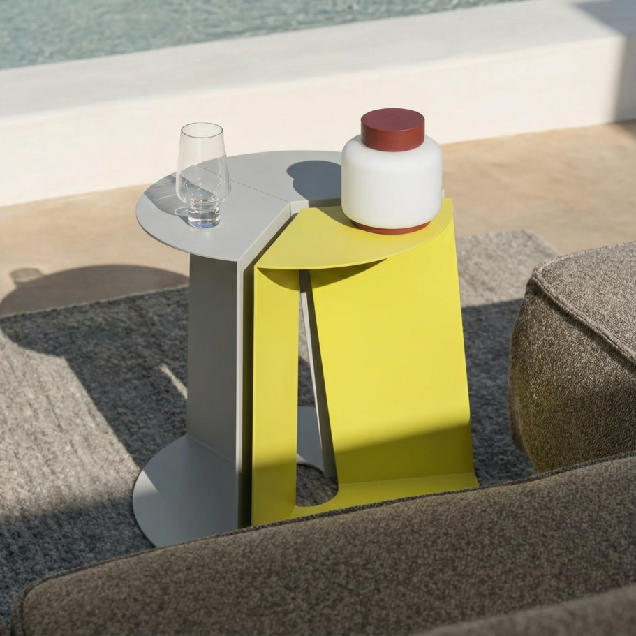 Moderne Beistelltisch in Grau und Gelb mit Glas und dekorativem Behälter.